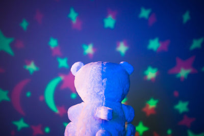 Sound soother bear with star projection on wall.