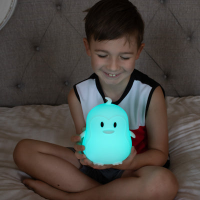 Child with LumiPenguin glowing blue.