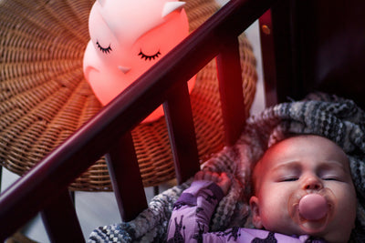 LumiPet Owl beside crib with baby sleeping.