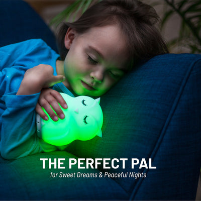 The perfect pal - Child sleeping with green LumiOwl Bluetooth glowing green.