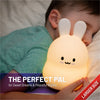 The perfect pal - larger size - Boy sleeping with LumiBunny glowing yellow.