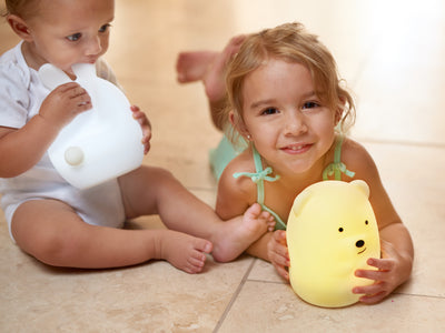 Two children holding LumiBunny and LumiBear nightlights.