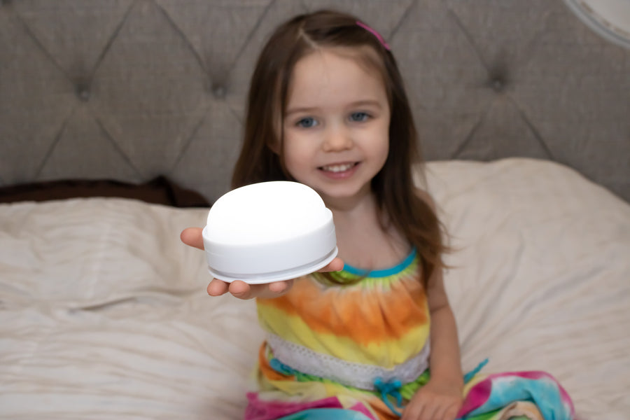 Child holding LumiPet light base. 